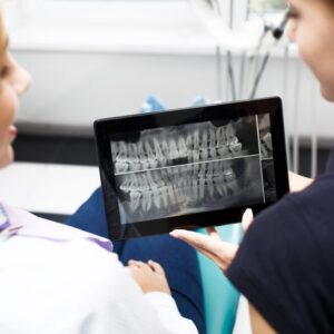 A imagem mostra um procedimento odontológico com uso de tecnologia