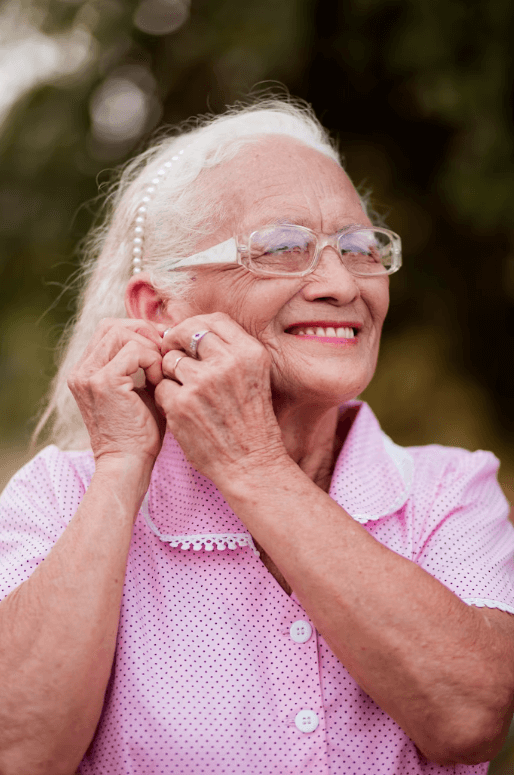 Idosa sorrido pois mostrando seu cuidado com os dentes na terceira idade